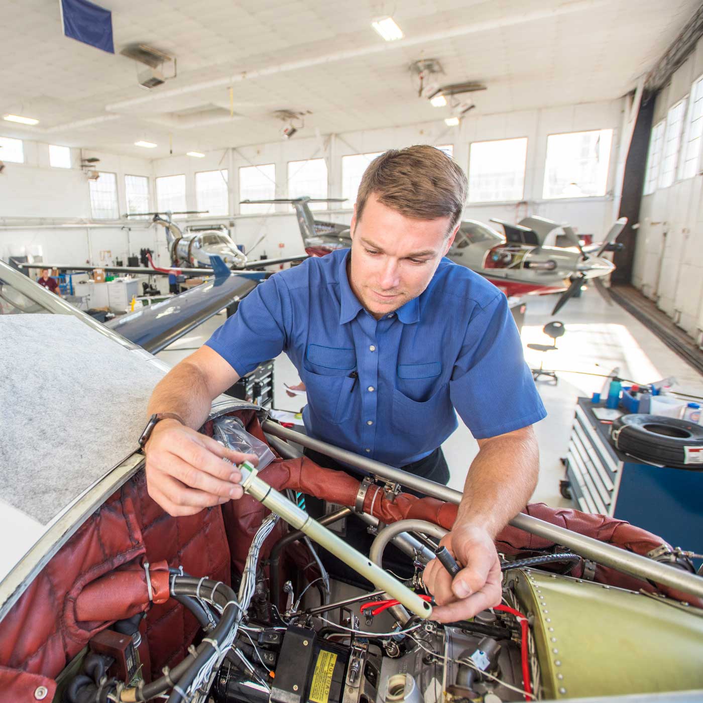 A man working on the engine of an airplane.